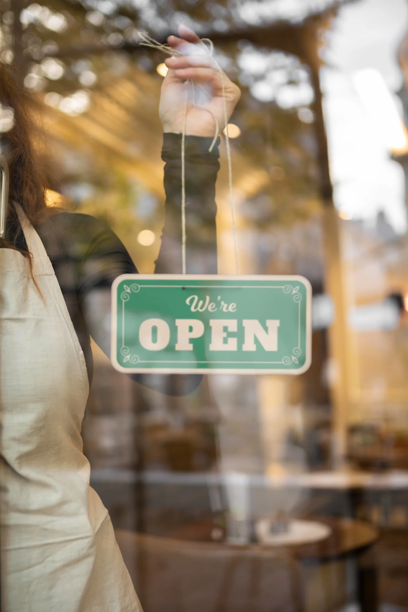 Commerçante installant une pancarte ouvert sur sa boutique